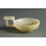 Chinese jade handled libation cup, the shallow vessel raised on a low splayed foot, with an