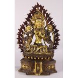 Himalayan copper alloy sculpture of Tara, seated on a lotus pedestal holding lotus sprigs, backed by