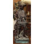 Patinated bronze sculpture of a young hunter carrying a rabbit and duck, rising on a naturalistic