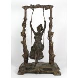 Patinated metal figural sculpture, depicting a lady on a swing centered between the naturalistic