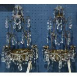 Pair of French style patinated metal and crystal sconces, each having facted drops above three