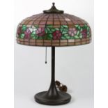 Arts and Crafts leaded glass table lamp, having a dome floral decorated shade, and rising on a