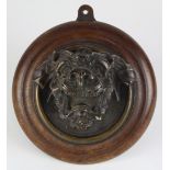 Continental wall bracket, 19th century, having a circular wood mount fronted by the patinated bronze