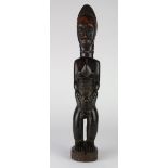 Baule, Cote d'Ivoire standing female figure, glossy and overly polished, with oversized hands on her