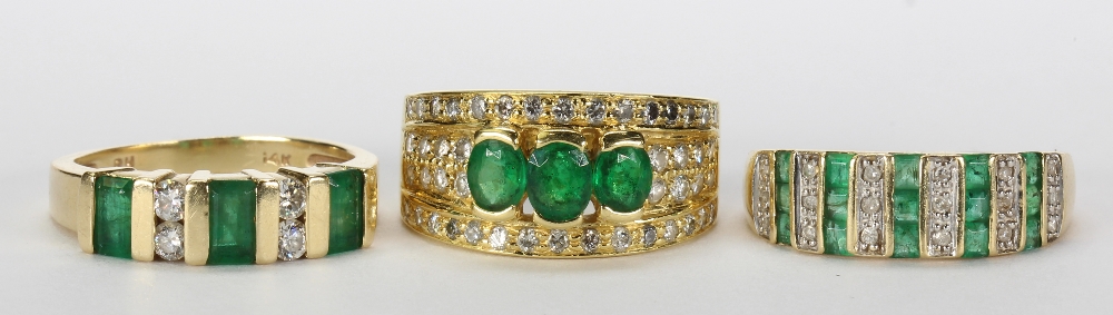 (Lot of 3) Emerald, diamond and yellow gold rings including one ring featuring (3) oval cut emeralds