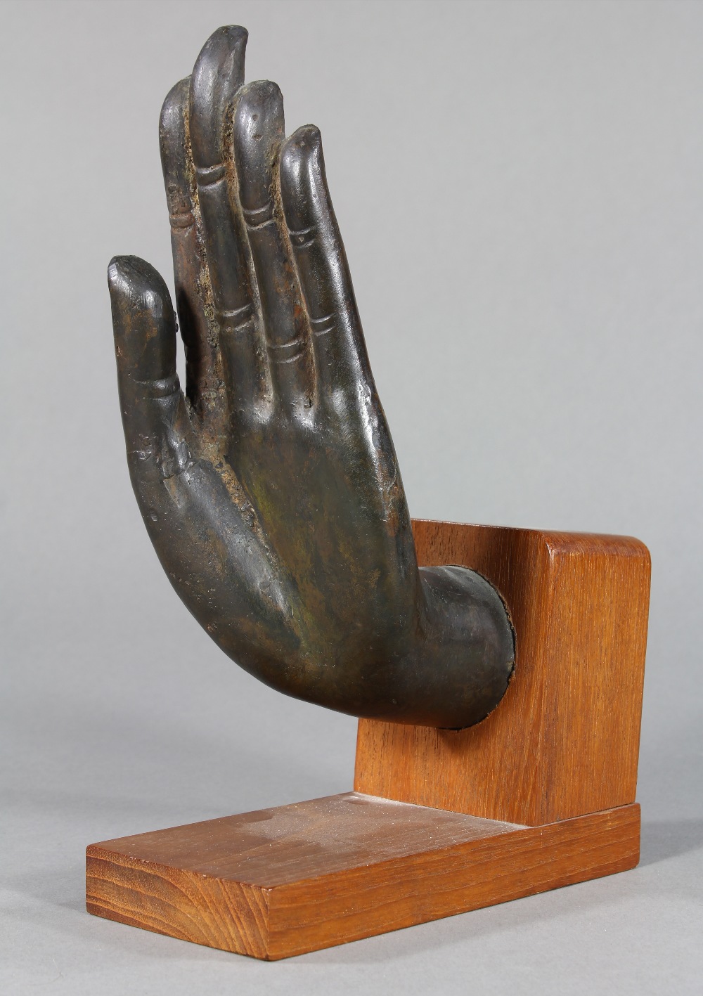 Thai bronze fragment of a hand, possibly from a Buddha, in abhaya mudra, with wood stand, overall: