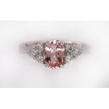 Sapphire, diamond and 18k white gold ring featuring (1) oval-cut pink sapphire, weighing