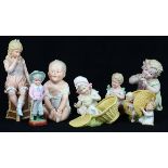 (Lot of 8) German porcelain bisque figural group, each depicting a young child or infant, polychrome