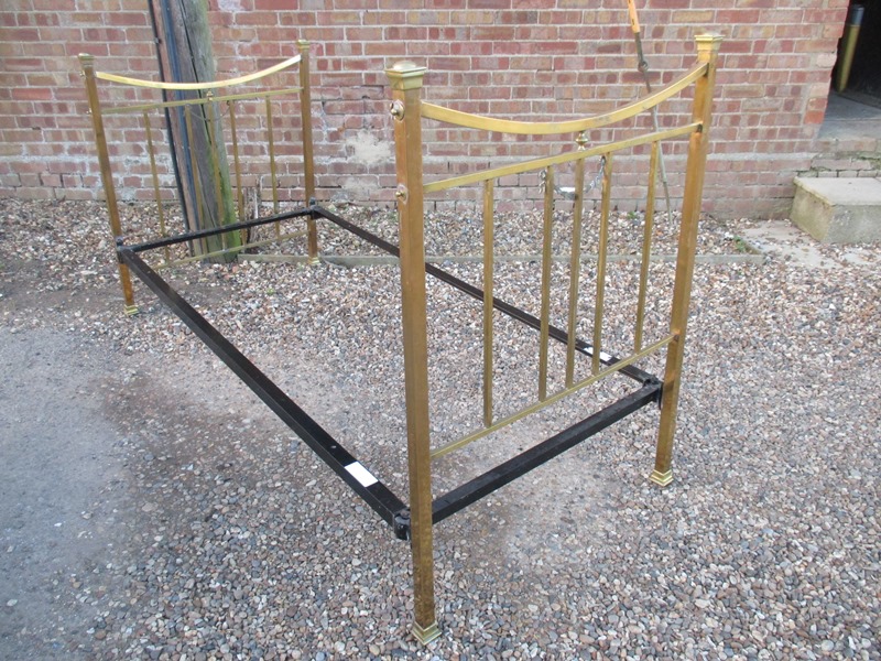 A vintage brass bed with modern base