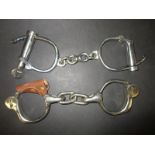 A pair of vintage handcuffs by H R Arms Co and another by Hiatt
