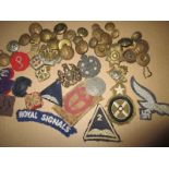 A quantity of military cloth & metal badges and buttons
