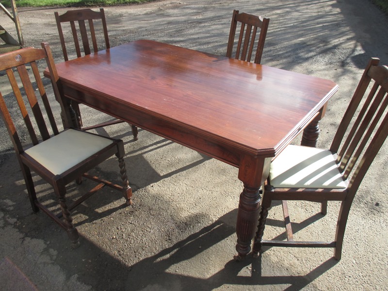 An antique dining table with 4 chairs