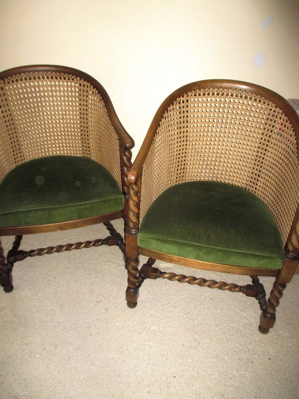 A pair of cane armchairs with upholstered seat pad