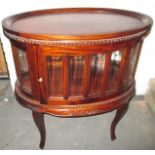 An early 20th century glazed drinks cabinet with removable tray top