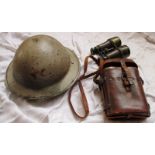 A Brodie tin hat and a pair of military field glasses