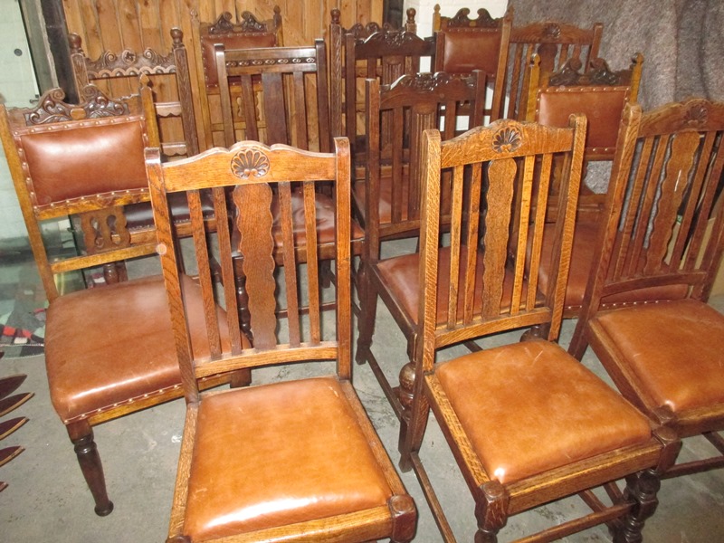 A harlequin set of 14 oak dining chairs with brown leather covers