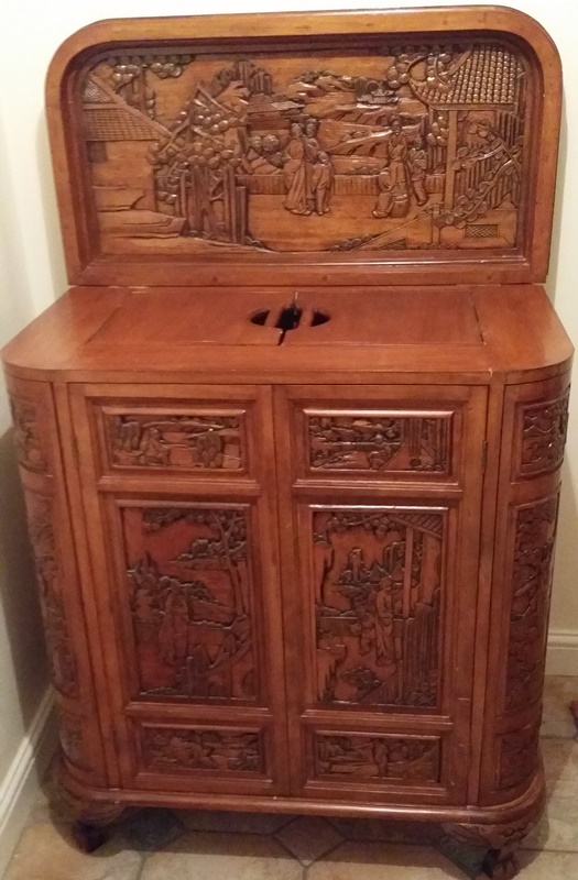 An oriental carved wood multi compartment cabinet
