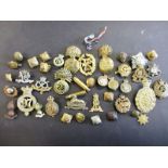 A quantity of military cap badges and buttons