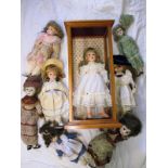 A quantity of vintage porcelain dolls one in glazed case