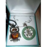 An owl necklace set with amber and a jade example