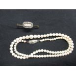 A diamond set mourning brooch and a pearl necklace