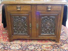 A Heavily Carved Oak Sideboard With African Influe