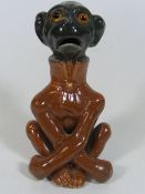 A Continental, Probably German Pottery Seated Monk