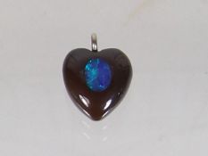 An Opal Mounted Within Heart Shaped Pendant