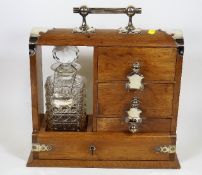 An Antique Oak Tantalus With Silver Plate Fittings