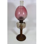 A Late Victorian Oil Lamp With Etched Cranberry Sh