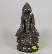 A Chinese White Metal Statue Featuring Three Faced Buddha