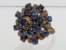 A Ladies Yellow Metal & Blue Stone Cluster Ring