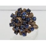 A Ladies Yellow Metal & Blue Stone Cluster Ring