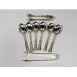 A Set Of Silver Spoons With One Silver Set Of Tong