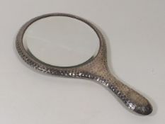 An Antique Silver Mirror With Hammered Finish