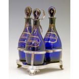 Set of three early 19th Century Bristol Blue glass club shaped decanters, each having a gilt title
