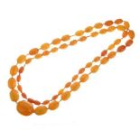 Graduated row of reconstituted amber, fifty-five beads measuring 102cm long, 73g gross Condition: