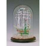 Nailsea type glass frigger in the form of two sailing ships and a lighthouse, displayed beneath a