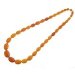 Graduated row of reconstituted amber, thirty-five beads measuring 56cm long, 48g gross Condition: