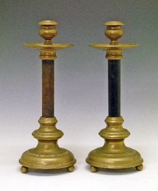 Pair of early 20th Century Skultuna brass and ebonised candlesticks, each having a wide drip tray