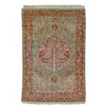 Persian silk rug having a central medallion decorated with a tree amongst tight-knit foliage on a