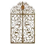 Pair of large decorative cast and wrought iron arch shaped gates, having allover foliate scroll