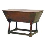 Antique oak dough bin of tapered rectangular form, standing on tapered turned supports united by