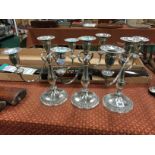 A set of three twin branch silver plated candelabra.