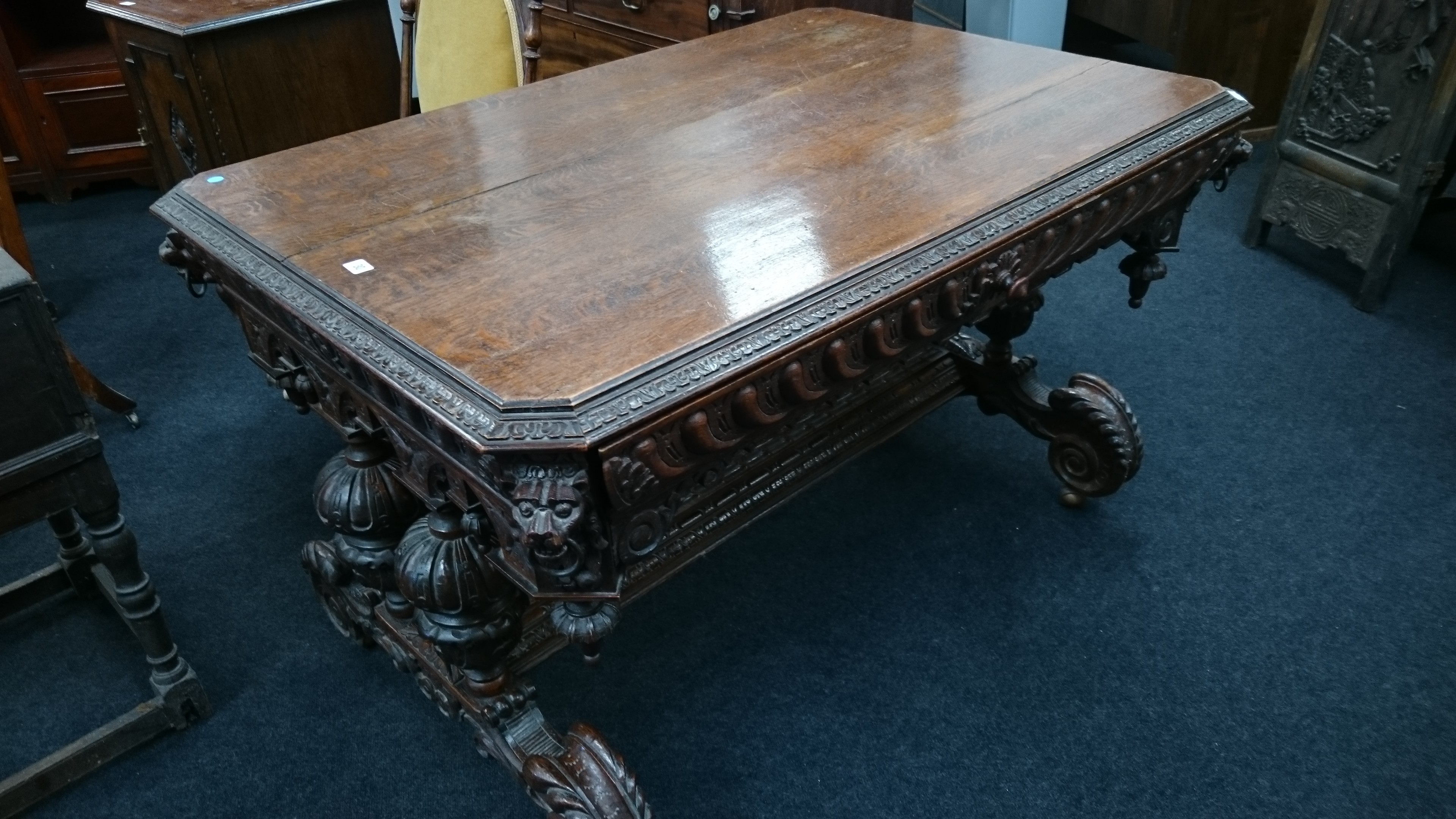 A large oak centre table with frieze drawer to front decorated with lion mask corners,