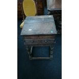 An early oak child's lift-top desk with panelled drawer to front,