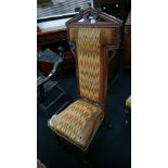 A mahogany framed upholstered prayer chair, resting on turned supports to front castors.