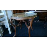 A walnut quarter veneered circular centre table with decorative cross stretcher,