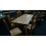 A large French oak farmhouse dining table together with six matching ladder back oak framed chairs