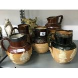 Five various 19th century Doulton stoneware jugs including two with silver rims together with a